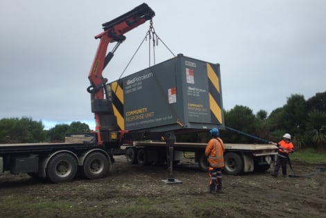 Staff removing a container from a truck